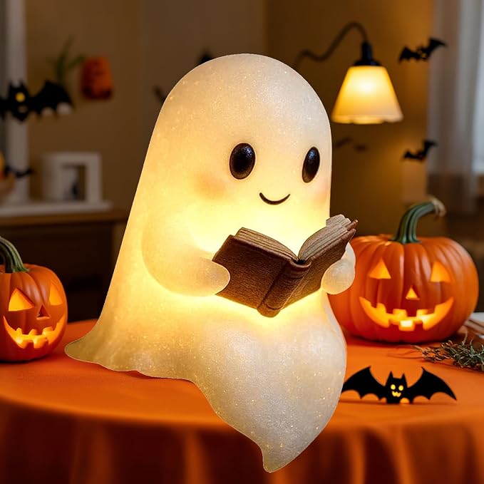 A 3D-printed silicone ghost reading lamp sitting on a shelf with a warm LED glow.