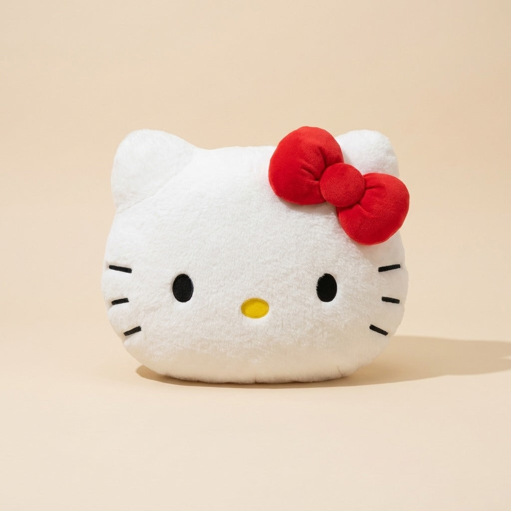 A white Hello Kitty plush pillow shaped like her face, featuring a red bow, black embroidered eyes and whiskers, and a small yellow nose, set against a solid beige background.
