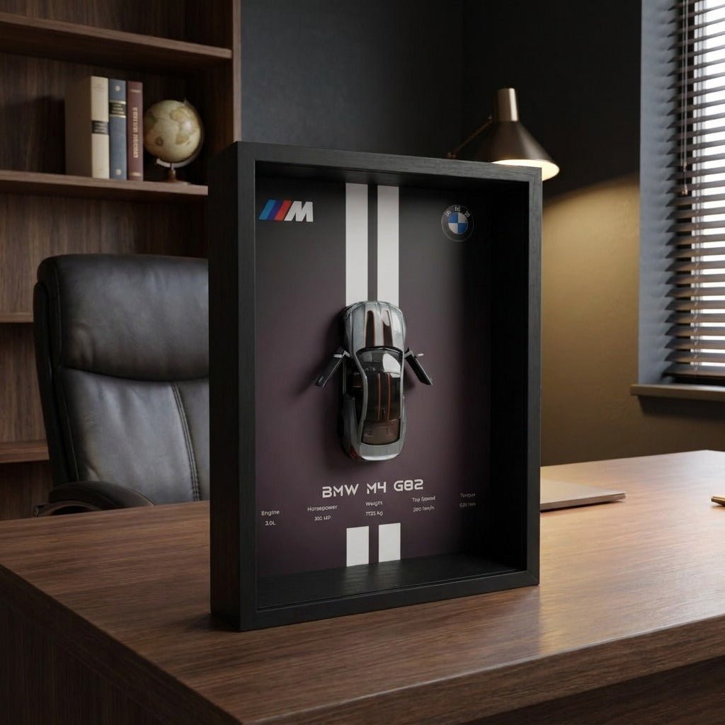BMW M4 3D Framed Diecast Wall Art in a 32cm x 23cm black shadow box frame, featuring a grey 1:32 scale model car with open doors against an M-Power design background with performance stats.