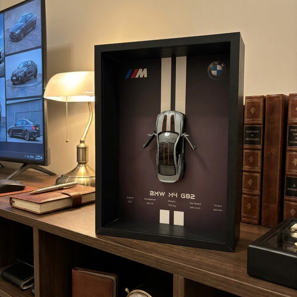 BMW M4 3D Framed Diecast Wall Art in a 32cm x 23cm black shadow box frame, featuring a grey 1:32 scale model car with open doors against an M-Power design background with performance stats.