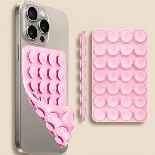 Pink silicone suction cup phone case shown installed on a silver smartphone, alongside the flat unrolled case and a separate strip of suction cups on a light beige background.